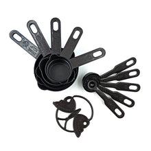 Set of black plastic measuring cups and spoons, featuring a butterfly-shaped holder for organization